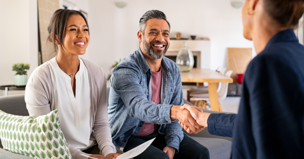 a couple of people sitting on a couch shaking hands with a partner